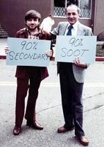 Daniel Grosjean and Tica Novakov holding signs reading 90% secondary and 90% soot